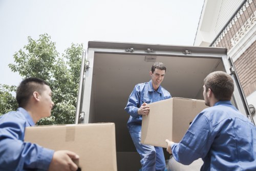 Local movers carrying business items through a Swiss Cottage building