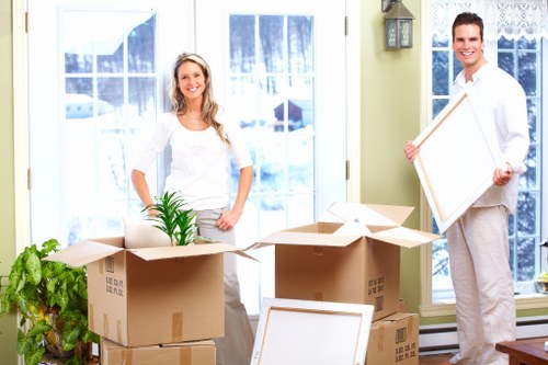 Professional movers carrying boxes near Swiss Cottage apartment building